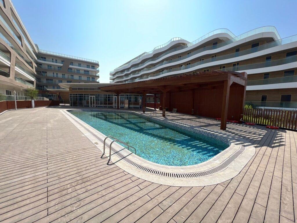 Sunset view of Qaryat Al Hidd waterfront community with premium residences and lush greenery on Saadiyat Island.